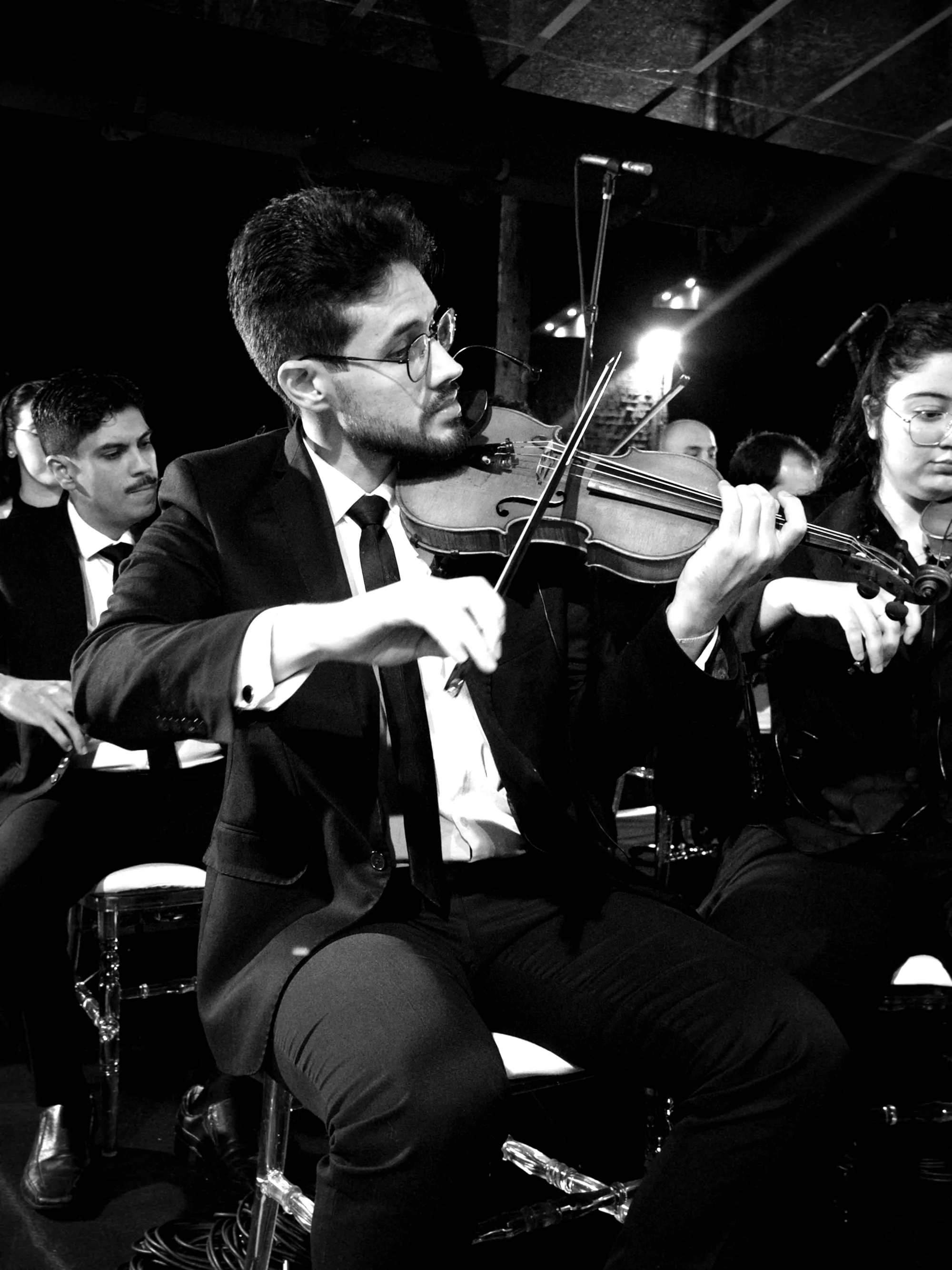 Violinista da Filarmônica Aruna durante apresentação, em primeiro plano
